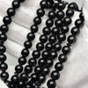 Détail perles de chapelet Tijani - texture lisse et brillance naturelle du corail noir