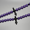 Gros plan pendentif Yusr noir et chaînes du tasbih Marjane violet bicolore